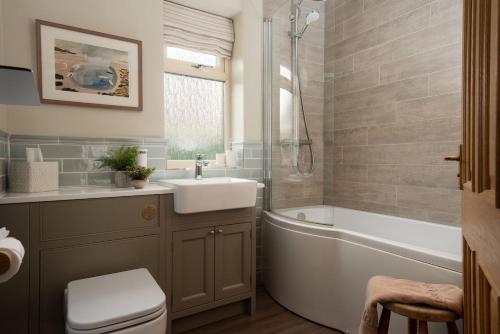 Un baño con bañera, lavabo e inodoro. en Greengate, en Seahouses