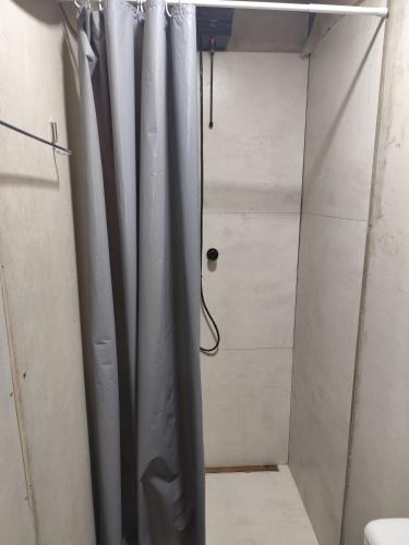 een douche met een douchegordijn in de badkamer bij Small house in Itajaí