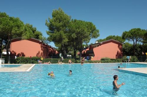 eine Gruppe von Personen, die in einem Schwimmbad schwimmen in der Unterkunft Ferienhaus für 6 Personen ca 46 qm in Bibione, Adriaküste Italien Bibione und Umgebung in Bibione