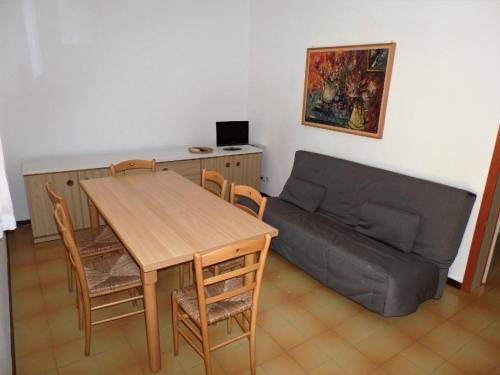 ein Wohnzimmer mit einem Tisch und einem Sofa in der Unterkunft Ferienhaus für 6 Personen ca 46 qm in Bibione, Adriaküste Italien Bibione und Umgebung in Bibione