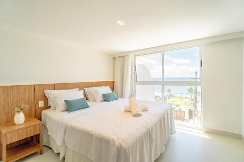 a bedroom with a large bed with a large window at Vip Praia Hotel in Natal