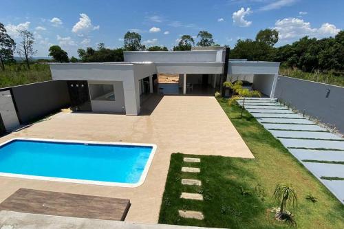 a house with a swimming pool in front of it at Sítio Gilmar2filhas in Sete Lagoas