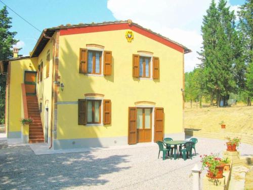 ein kleines gelbes Haus mit einem Tisch und Stühlen in der Unterkunft Studio für 6 Personen ca 60 qm in Martignana, Toskana Provinz Florenz in Marcignana