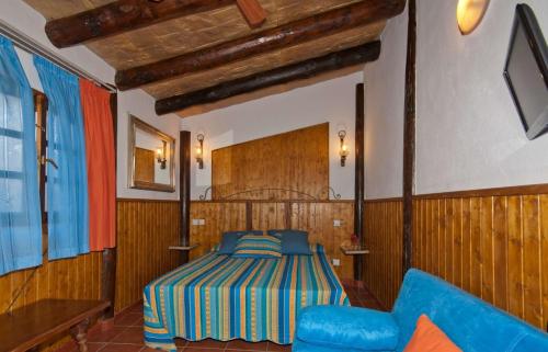 um quarto com uma cama e um sofá azul em Ferienhaus für 5 Personen ca 58 qm in Arucas, Gran Canaria Nordküste Gran Canaria em Arucas