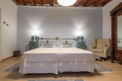 een slaapkamer met een wit bed en een stoel bij Ferienhaus für 4 Personen ca 120 qm in Ingenio, Gran Canaria Binnenland Gran Canaria in Ingenio