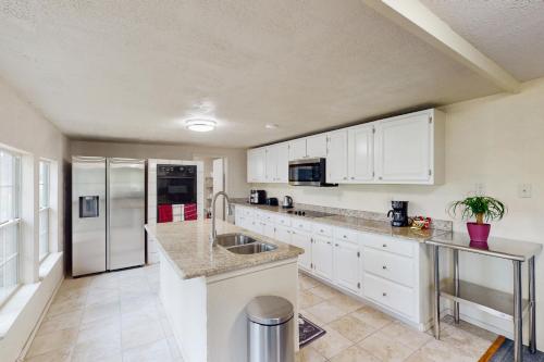 a kitchen with white cabinets and a stainless steel refrigerator at Quinlan Ranch in Quinlan
