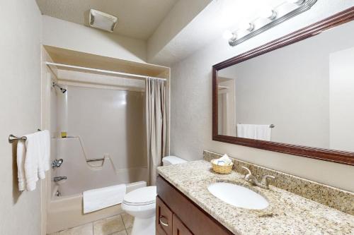 a bathroom with a sink and a toilet and a mirror at Quinlan Ranch 