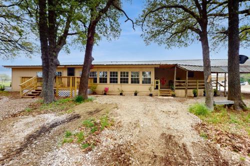 a yellow house with trees in front of it at Quinlan Ranch in Quinlan