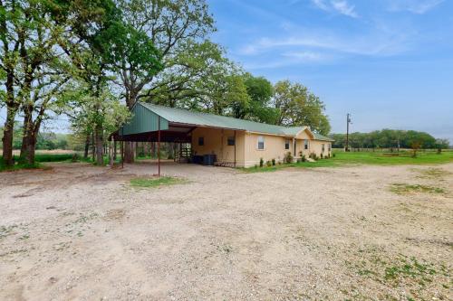 a small house with a green roof in a field at Quinlan Ranch in Quinlan