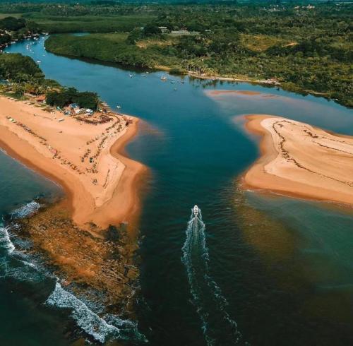 an aerial view of a body of water with a beach at Pousada Crocodilo Caraíva in Caraíva