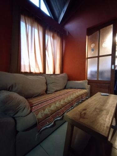 sala de estar con sofá y mesa de madera en Hogar cerca del aeropuerto en Ushuaia