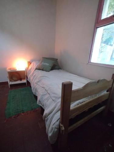 1 dormitorio con 1 cama en una habitación con ventana en Hogar cerca del aeropuerto en Ushuaia