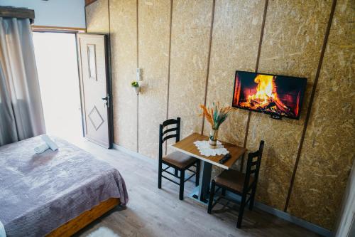 ein Schlafzimmer mit einem Bett und einem Tisch mit einem Kamin in der Unterkunft Bujtina ANLU in Gjirokastër