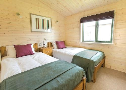 מיטה או מיטות בחדר ב-Wighill Manor Lodges