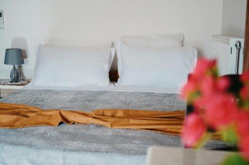 a bedroom with a bed with white pillows at Bujtina ANLU in Gjirokastër