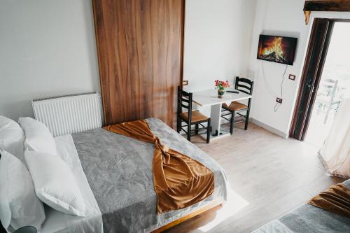 a bedroom with a bed and a table with chairs at Bujtina ANLU in Gjirokastër