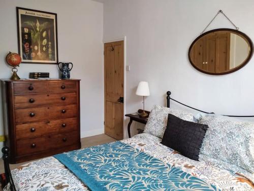 a bedroom with a bed with a dresser and a mirror at The Cobbles - Central, Parking, Netflix & Woodburner in Hebden Bridge