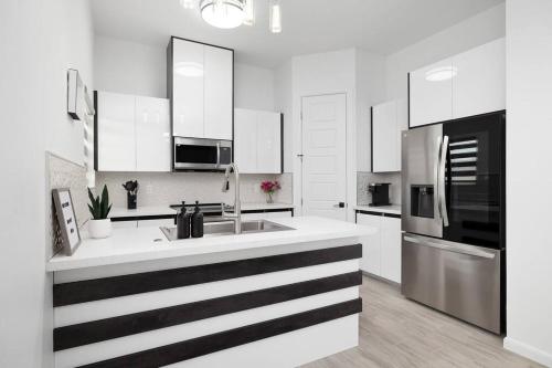 a white kitchen with a sink and a refrigerator at Quinta Real 5125 in McAllen
