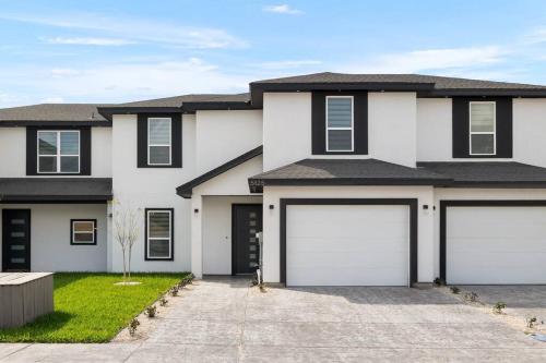 a house with two white garage doors at Quinta Real 5125 in McAllen