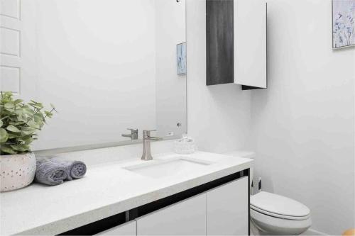 a white bathroom with a sink and a toilet at Quinta Real 5125 in McAllen