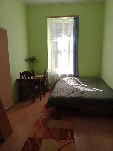 sypialnia z łóżkiem, stołem i oknem w obiekcie Apartament koło Dworcu w mieście Przemyśl