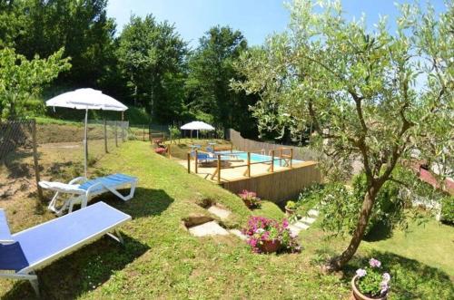 um jardim com bancos e guarda-sóis num quintal em Ferienhaus mit Privatpool für 2 Personen ca 40 qm in Capannori, Toskana Provinz Lucca em Capannori