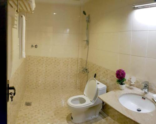 a bathroom with a toilet and a sink at Triple One Hotel Suites in Abbottabad