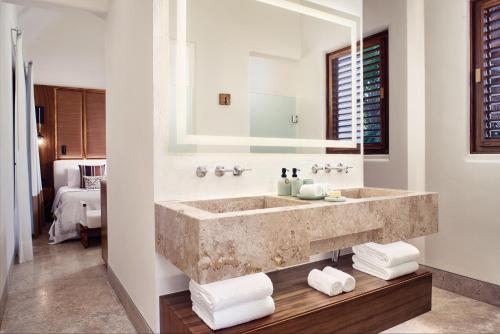 baño con lavabo grande y espejo en Casa Chablé en Punta Allen