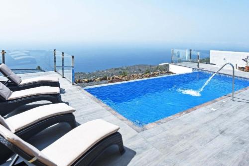 una piscina con tumbonas y una piscina en Ferienhaus mit Privatpool für 6 Personen ca 120 qm in Tijarafe, La Palma Westküste von La Palma, en Tijarafe