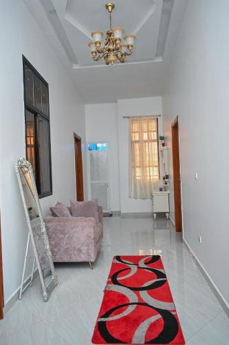 ein Wohnzimmer mit einem Sofa und einem roten Teppich in der Unterkunft Tosh Home in Chukwani