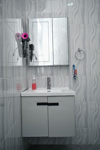 a bathroom with a white sink and a mirror at Tosh Home in Chukwani