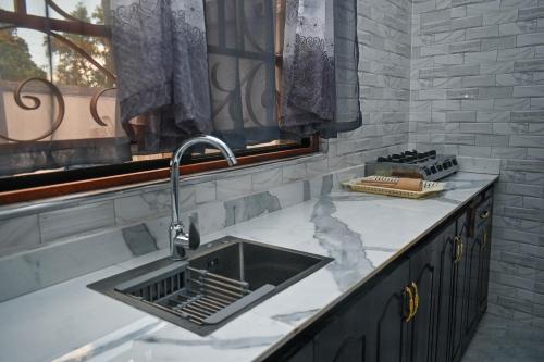 a kitchen counter with a sink and a window at Tosh Home in Chukwani