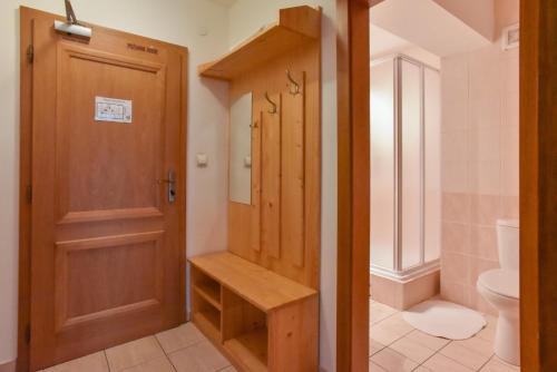 een badkamer met een toilet en een houten deur bij Penzion Kormoran in Námestovo
