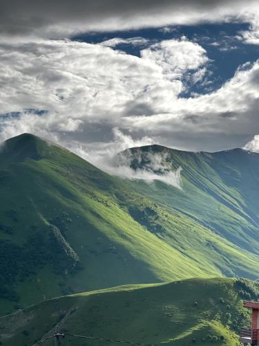 a view of a green mountain under a cloudy sky at Gogi Resort in Gudauri