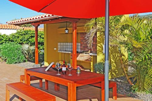 a table with wine glasses and an umbrella on a patio at Ferienhaus mit Privatpool für 6 Personen ca 108 qm in Las Manchas, La Palma Westküste von La Palma in Puerto Naos