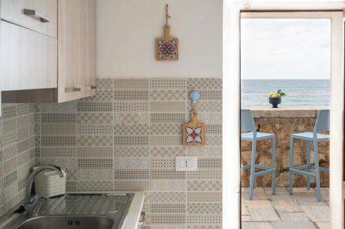 a kitchen with a sink and a view of the ocean at Le Mura - Melilli in Trapani