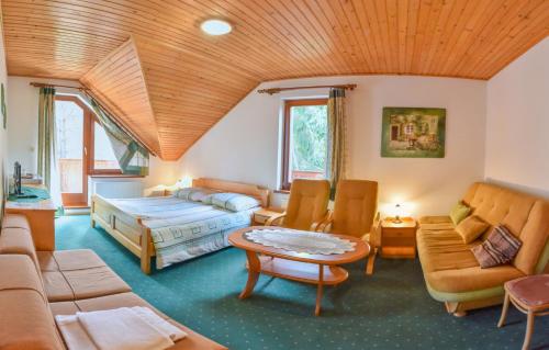 een woonkamer met een bed, een bank en een tafel bij Penzion Kormoran in Námestovo