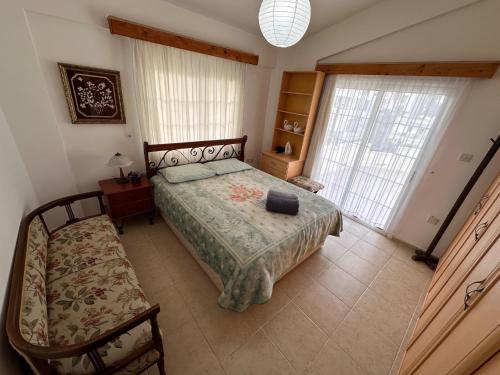 a bedroom with a bed and a bench and windows at Kyrenia center 3 bedroom apartment in Kérynia