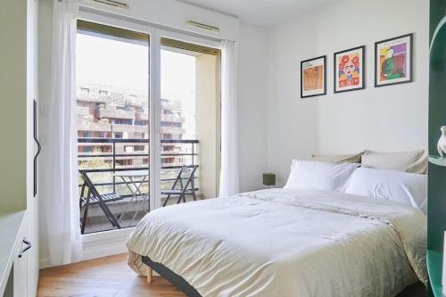une chambre blanche avec un lit et une grande fenêtre dans l'établissement Luxury apartment 10 min from Eiffel Tower, à Paris