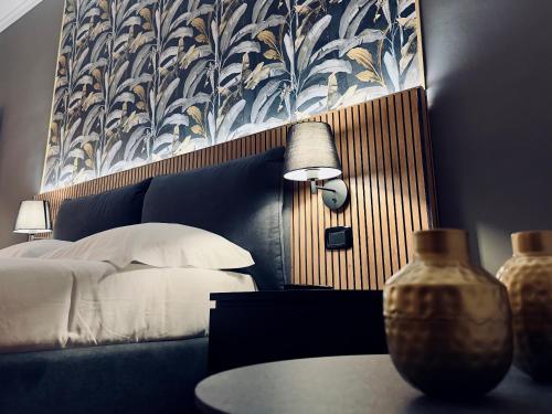 a bedroom with a bed and a table with a lamp at La Fontana Luxury Apartment in Nettuno