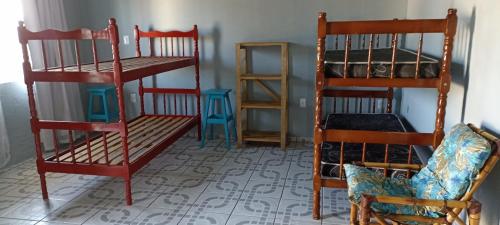 a room with two bunk beds and a chair at Kitnet Região Central in Itapoa