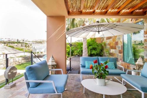 eine Terrasse mit blauen Stühlen und einem Sonnenschirm in der Unterkunft Ferienhaus für 4 Personen ca 98 qm in Las Crucitas, Gran Canaria Südküste Gran Canaria in Maspalomas