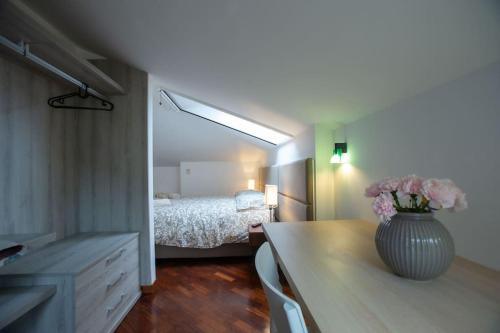 una camera da letto con un letto e un vaso con fiori su un tavolo di [Terrazzino Vista Mare] Idromassaggio Wi-Fi A/C a Porto San Giorgio