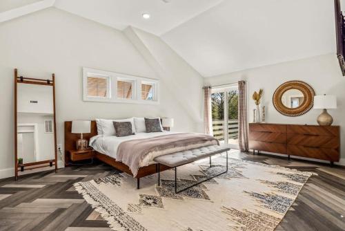 a bedroom with a large bed and a mirror at Sojourn Aurora 7 BR Pool & Hot Tub in Corolla