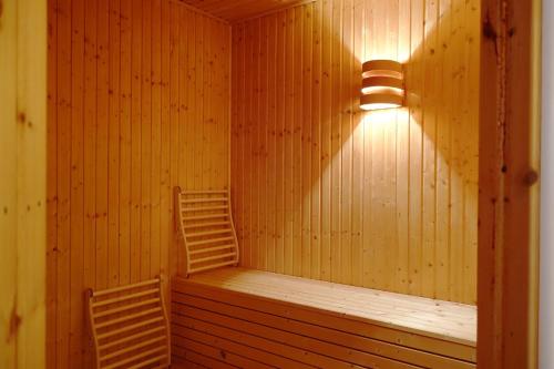 a sauna with two chairs and a light on the wall at Ferienhaus mit Sauna b in Zingst