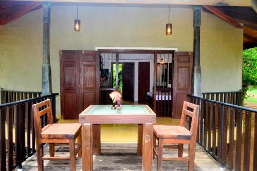 a table and two chairs on a porch at Guruwaththa Eco Lodge in Hikkaduwa