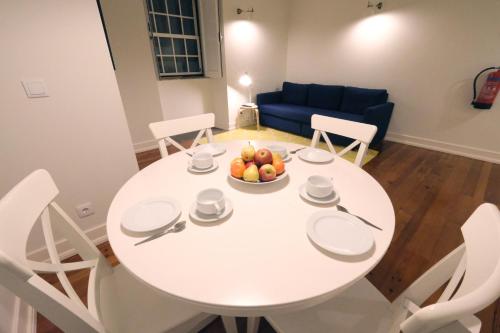 a white dining room table with a bowl of fruit on it at Apartamentos Ázera - António Ázera in Praia da Vitória