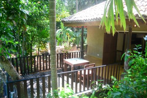 a porch of a house with a table and a fence at Guruwaththa Eco Lodge in Hikkaduwa