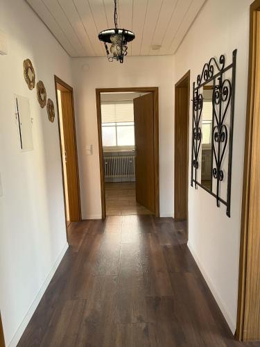 an empty hallway with wood floors and a chandelier at Ferienwohnung zur Langen Meile in Kalteneggolsfeld