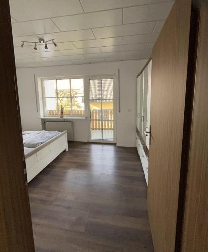 an empty room with a bed and two windows at Ferienwohnung zur Langen Meile in Kalteneggolsfeld